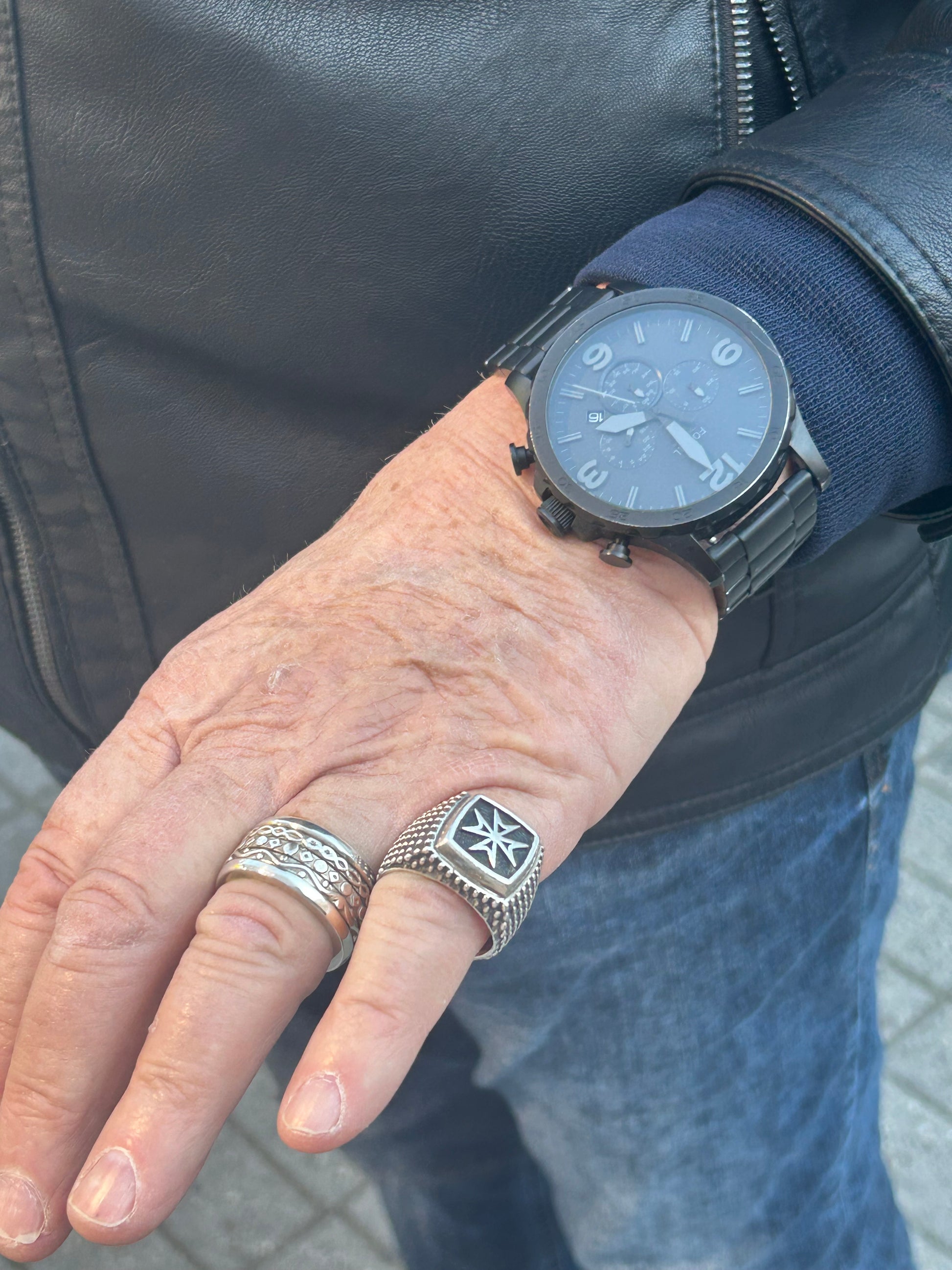 Anello uomo in argento 925 a tre fasce con texture martellata indossato insieme ad altri anelli artigianali di De Giorgi Gioielli
