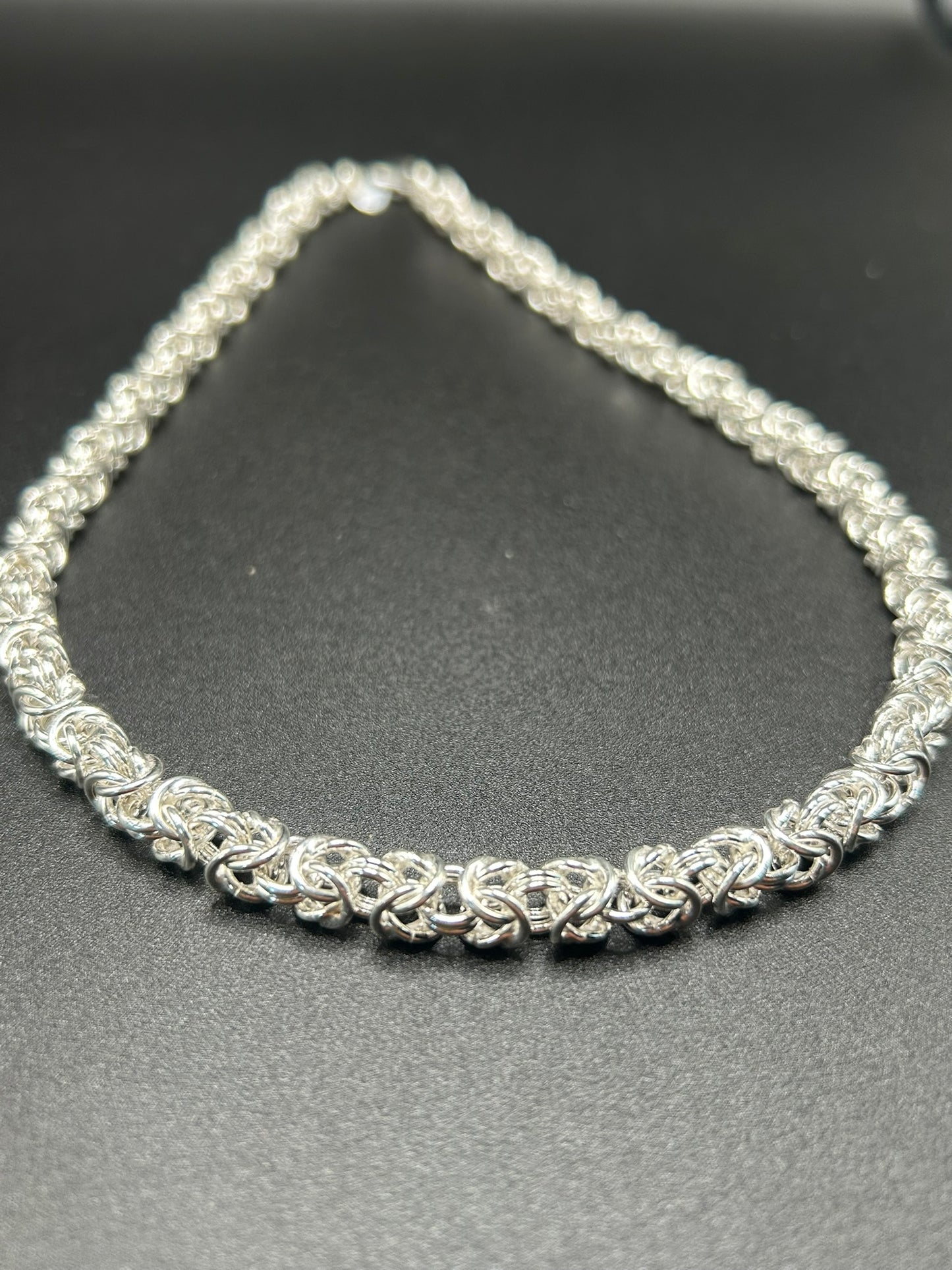 Bisanzio nasce dall'incontro tra una lavorazione antica e un'estetica contemporanea. Una fitta successione di elementi in argento 925 viene intrecciata  per creare la caratteristica maglia bizantina, ricca di volume e movimento.

Una collana dalla forte personalità, pensata per chi ama l'argento nella sua forma più materica e per chi cerca un gioiello artigianale capace di distinguersi senza essere eccessivo.