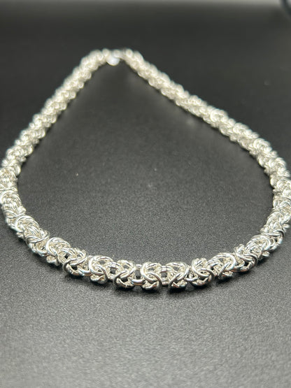 Bisanzio nasce dall'incontro tra una lavorazione antica e un'estetica contemporanea. Una fitta successione di elementi in argento 925 viene intrecciata  per creare la caratteristica maglia bizantina, ricca di volume e movimento.

Una collana dalla forte personalità, pensata per chi ama l'argento nella sua forma più materica e per chi cerca un gioiello artigianale capace di distinguersi senza essere eccessivo.