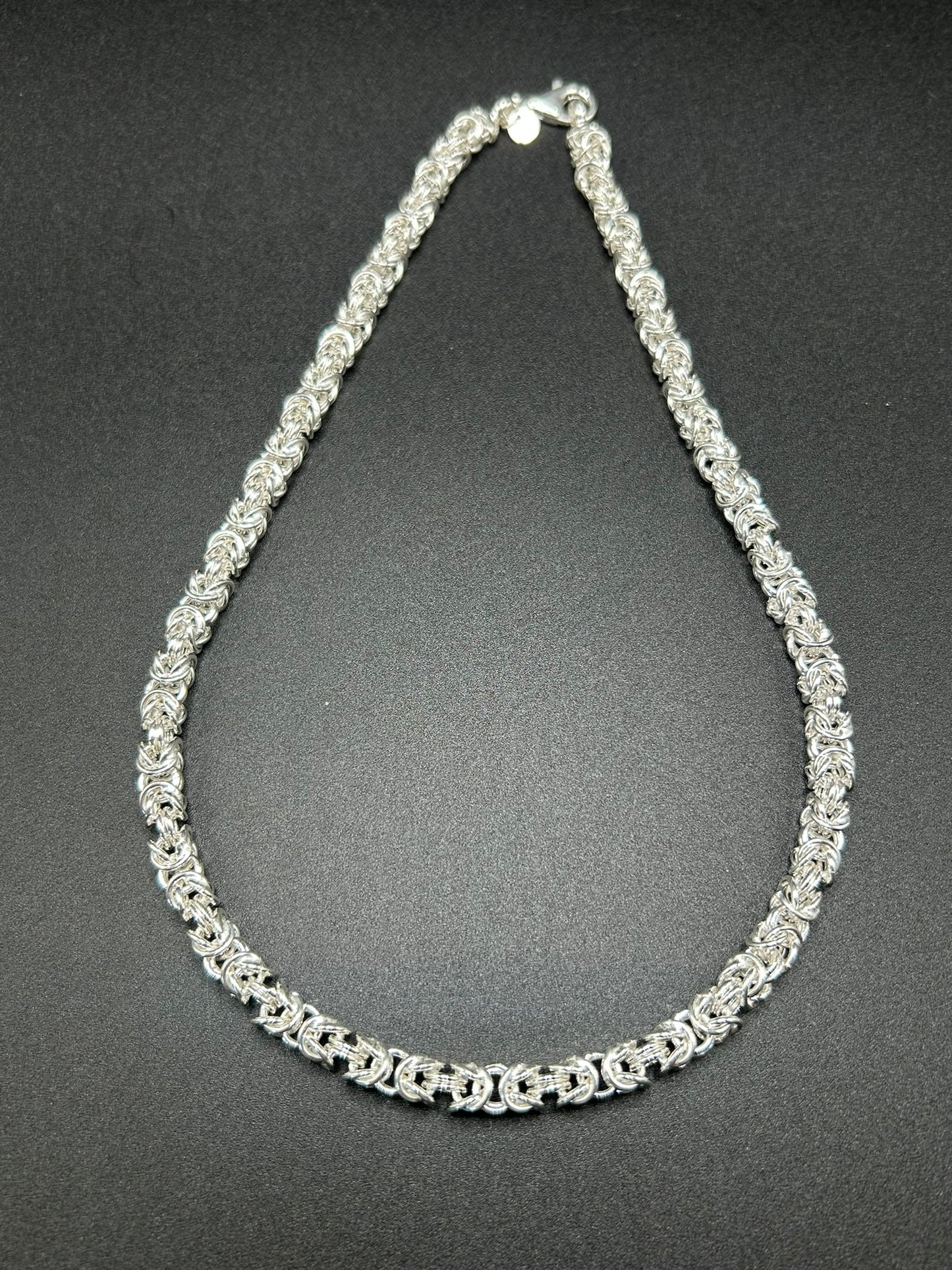Una collana importante, costruita interamente attraverso l’intreccio della tradizionale maglia bizantina. I singoli elementi in argento sterling 925 si susseguono creando una trama ricca e tridimensionale, capace di catturare la luce e dare carattere al gioiello.

E' una collana dal design deciso ma senza tempo, pensata per essere indossata da sola come protagonista.