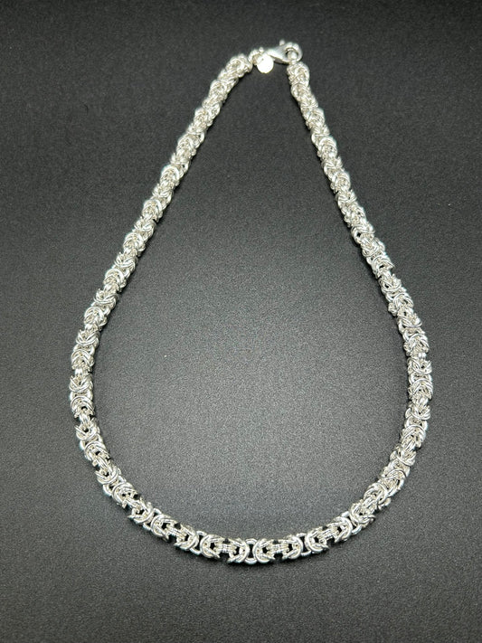 Una collana importante, costruita interamente attraverso l’intreccio della tradizionale maglia bizantina. I singoli elementi in argento sterling 925 si susseguono creando una trama ricca e tridimensionale, capace di catturare la luce e dare carattere al gioiello.

E' una collana dal design deciso ma senza tempo, pensata per essere indossata da sola come protagonista.
