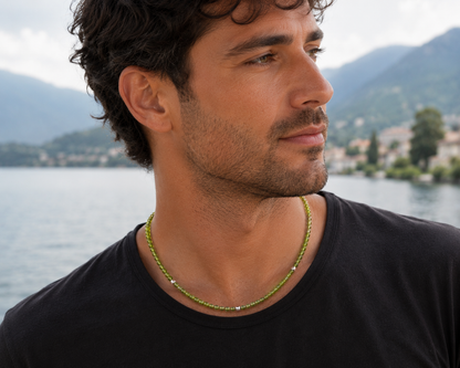 Man wearing a handmade natural peridot necklace with graduated faceted rondelle beads and three sterling silver 925 spacers by De Giorgi Gioielli.