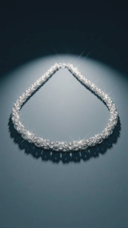 Collana Bizantina – Intreccio d’Argento. Un intreccio complesso di piccoli elementi in argento dà vita a una collana dalla presenza forte e raffinata. La lavorazione a maglia bizantina crea movimento, volume e continui giochi di luce, trasformando il metallo in una trama quasi tessile.